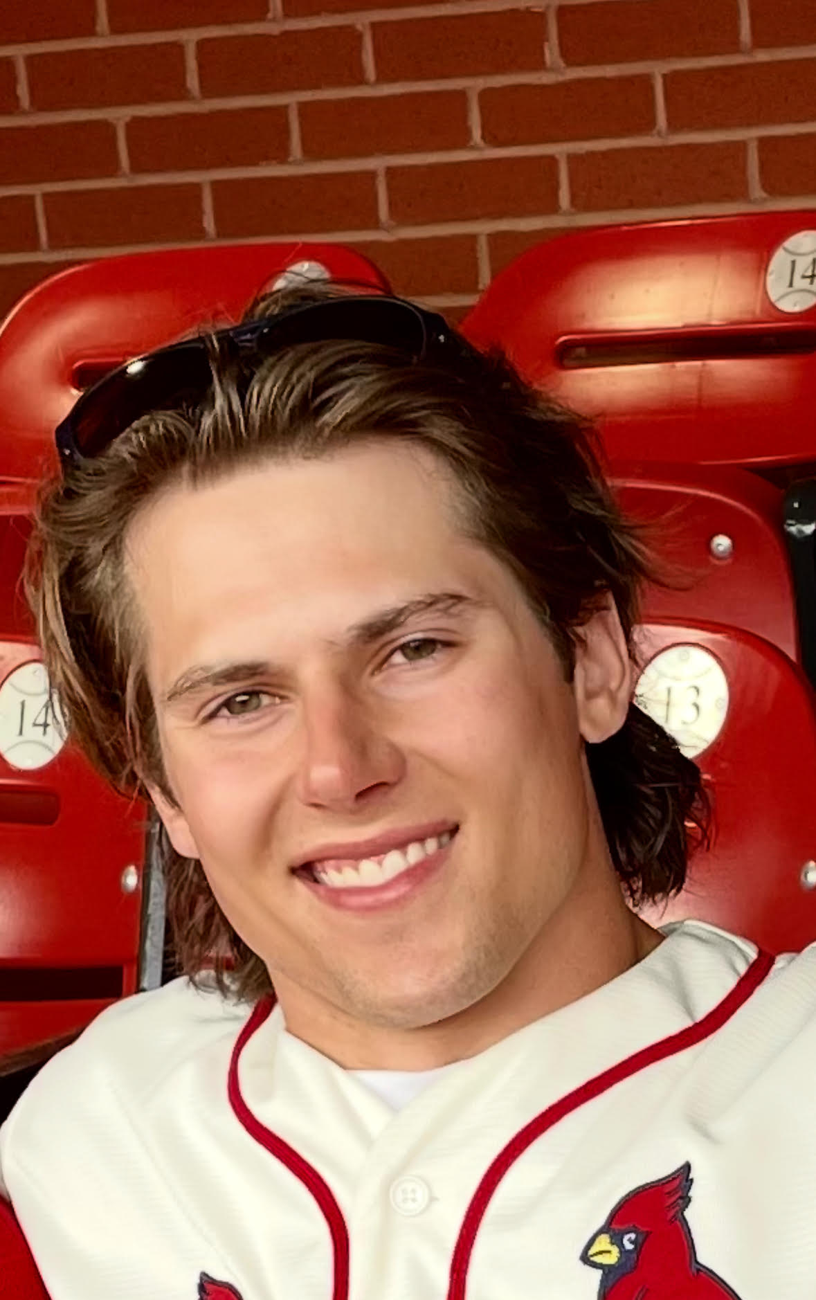 Andrew West smiling in a St. Louis Cardinals jersey at the ballpark